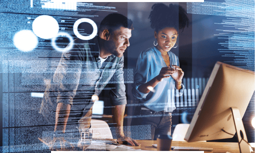 Two professionals collaborating on app development, analyzing code & digital interfaces on a computer screen in a workspace.